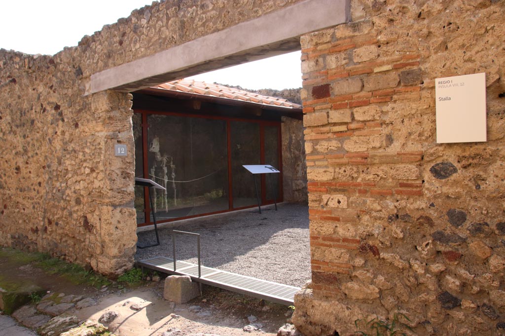 I.8.12 Pompeii. October 2022. 
Looking towards entrance doorway with “break” in pavement for passage of carts. Photo courtesy of Klaus Heese.