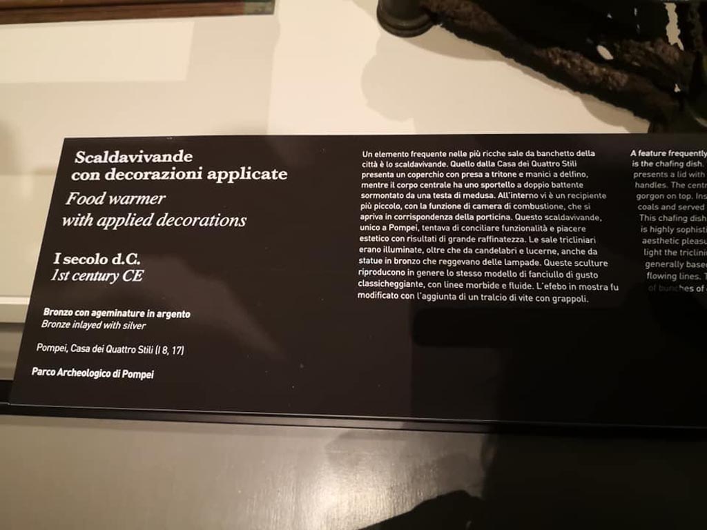 I.8.17 Pompeii. December 2019. Information card with food warmer. 
On display in exhibition “Pompei e Santorini” in Rome, 2019. Photo courtesy of Giuseppe Ciaramella.