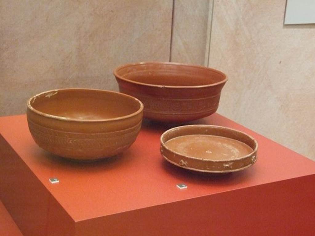 I.9.1 Pompeii. Terra sigillata cup (On left).  SAP 8286.  Photographed at “A Day in Pompeii” exhibition at Melbourne Museum.  September 2009.