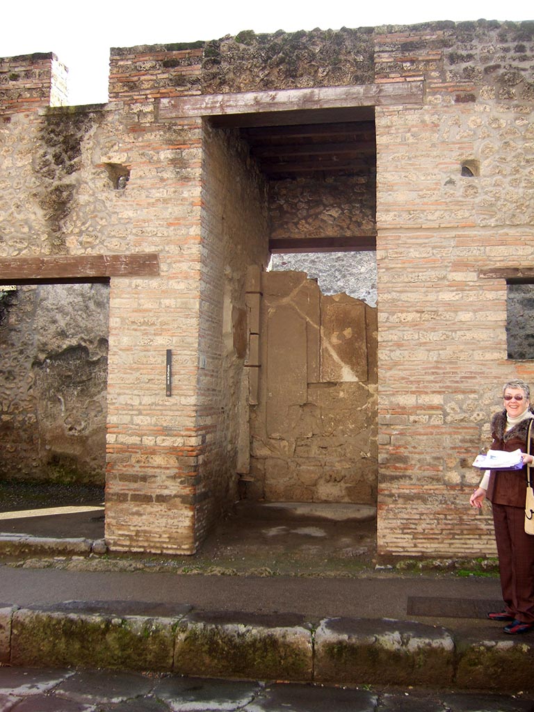 I.9.1 Pompeii. December 2005. Entrance.
According to Boyce, on both walls of the vestibule figures of six divinities had been painted.
The last refashioning of the façade destroyed two of the figures.
On the east wall were Mercury and Hercules, and a missing figure which Della Corte thought was Bacchus.
On the west wall were Minerva and Juno, and traces of a third figure which Della Corte suggested was Venus Pompeiana.
See Notizie degli Scavi di Antichità, 1913, p. 34.
See Della Corte, M., 1965. Case ed Abitanti di Pompei. Napoli: Fausto Fiorentino. (p.339).
See Boyce G. K., 1937. Corpus of the Lararia of Pompeii. Rome: MAAR 14. (p.110, no.3).