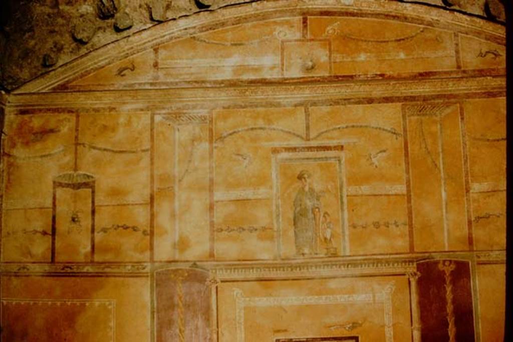 I.9.3 Pompeii. 1957. Room 10. Upper part of the west wall. The upper area was also yellow with a painting of Venus Pompeiana in the centre aedicula. In the side panels of the upper area, were hanging buckets separated by architectural views, garlands, borders with “carpet” pattern, and dolphins in the corners, and holes made by the support beams for the vaulted ceiling.  Photo by Stanley A. Jashemski.
Source: The Wilhelmina and Stanley A. Jashemski archive in the University of Maryland Library, Special Collections (See collection page) and made available under the Creative Commons Attribution-Non Commercial License v.4. See Licence and use details.
J57f0116