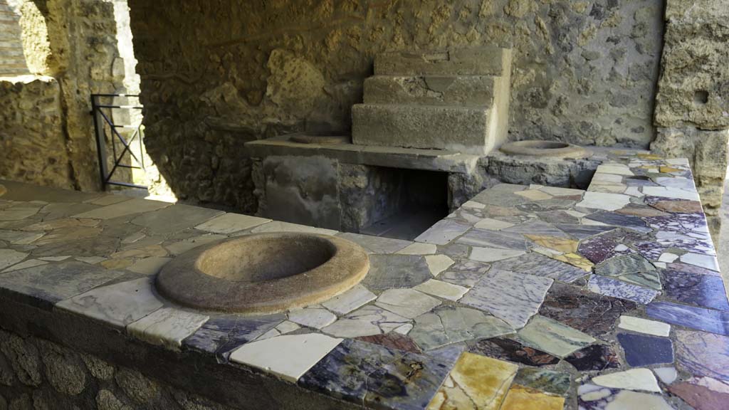 I.9.4 Pompeii. August 2021. Looking towards west wall with display shelving and two urns. Photo courtesy of Robert Hanson.