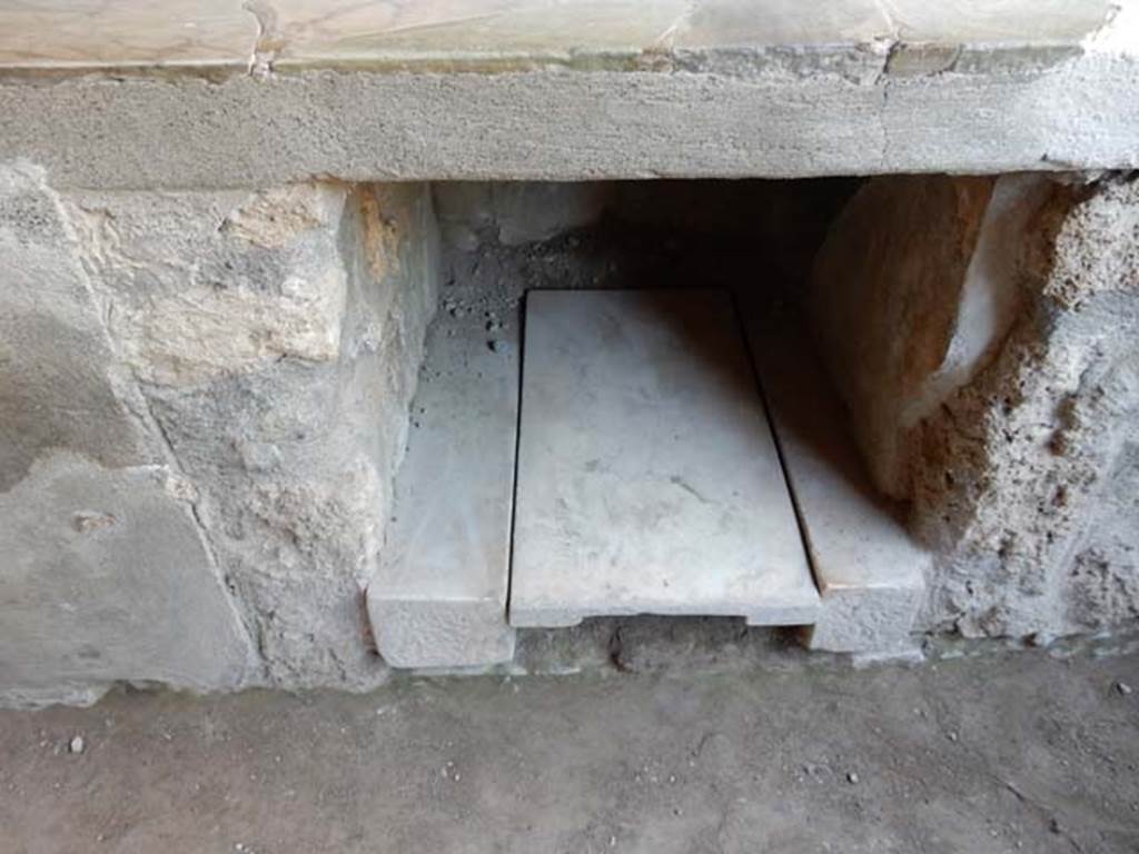 I.9.4 Pompeii. May 2015. Detail of recess under counter and display shelving against west wall. Photo courtesy of Buzz Ferebee.