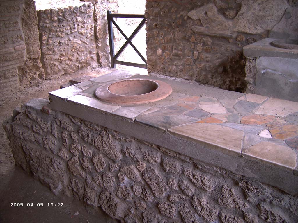 I.9.4 Pompeii. April 2005. East side of counter, with marble top and embedded dolium with hearth, on left. 
Photo courtesy of Klaus Heese.
