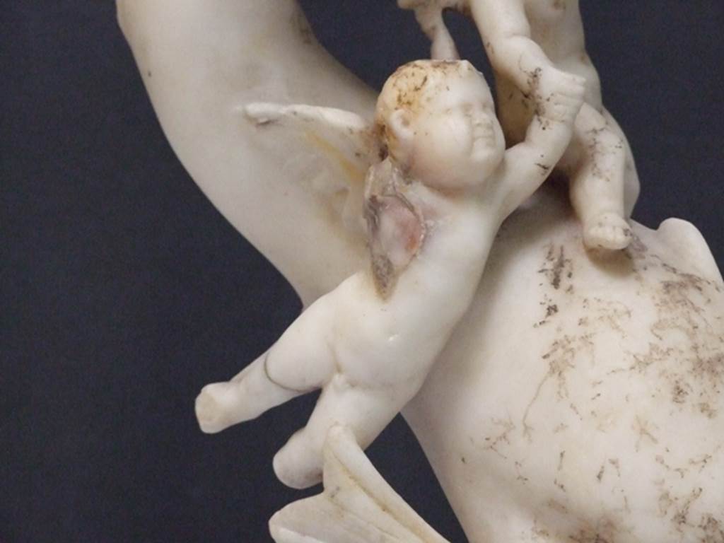 I.9.14 Pompeii. 2009. Marble fountain statuette. Two Amorini riding on dolphin.  
Detail of a cupid.   SAP inventory number 8128.  Found in 1951.