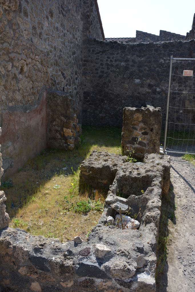 I.10.2 Pompeii. April 2017. 
Looking south across remains of podium, originally with two dolia and a hearth. 
In the south-east corner is a doorway to a rear-room. Photo courtesy Adrian Hielscher.