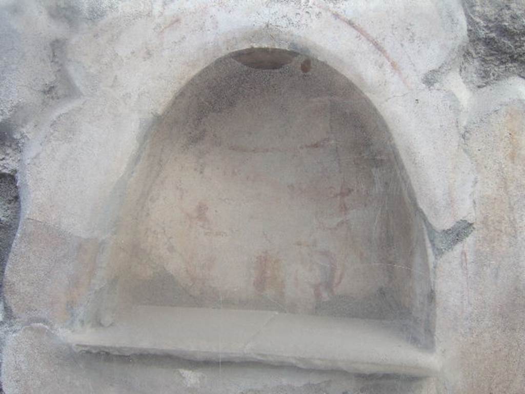 I.10.3 Pompeii. December 2006. Niche on east wall of fauces.
Fröhlich described a painted round altar, small snake, two Lares and an inscription “Felix aeris IV as, Florus X”.   See Fröhlich, T., 1991, Lararien und Fassadenbilder in den Vesuvstädten.  Mainz: von Zabern.  (L13 p.255).   Varone refers to the inscription as painted in red on a small aedicule located in the vestibulum. “Felix aeris as(sibus) IV, Florus X”.  
According to Varone, CIL IV 7339 is translated as “Felix for four asses, Florus for ten”. See Varone, A., 2001, Erotica Pompeiana: Love Inscriptions on the Walls of Pompeii.  Rome: L’ Erma di Bretschneider. (p.154). See Varone, A. and Stefani, G., 2009. Titulorum Pictorum Pompeianorum, Rome: L’erma di Bretschneider  (p.120 for a drawing of the graffito, which Varone and Stefani say is no longer conserved).