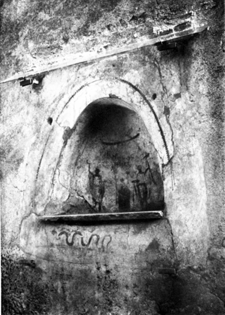 I.10.3 Pompeii. 1937. Niche on east wall of fauces. 
The red inscription “Felix aeris IV as, Florus X.” can be seen below the garland in the niche.
Comparing our photos and the original in NdS, and the angle of the graffiti recorded by Varone, show that Boyce’s photo in plate 14,2 is reversed.
His description saying the snake is “advancing r.” must therefore be taken to mean “from the right”.
See Boyce G. K., 1937. Corpus of the Lararia of Pompeii. Rome: MAAR 14, p. 27 no. 42, pl. 14,2 (the photo here has been reversed and corrected).
See Varone, A. and Stefani, G., 2009. Titulorum Pictorum Pompeianorum, Rome: L’Erma di Bretschneider, p. 120.