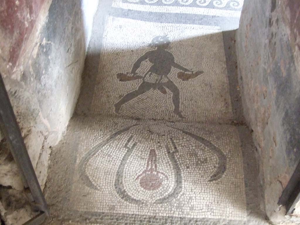 I.10.4 Pompeii. May 2006. Doorway to room 48, mosaic of figure carrying two askoi. 
An askos was an ancient Greek pottery vessel used to pour small quantities of liquids such as oil.
