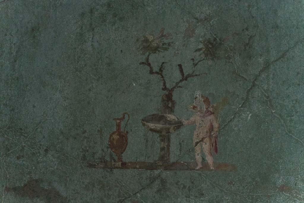 I.10.4 Pompeii. April 2022. 
Room 48, painted cupid with jug, fountain basin and tree in rectangular recess. Photo courtesy of Johannes Eber.