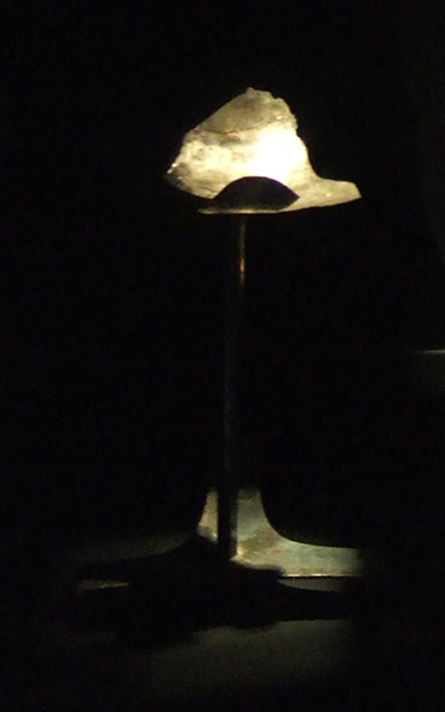 I.10.4 Pompeii. 
Support stand for display of silver phiale or flat drinking vessel with gold emblem. 
The stand has a triangular three footed base, a tall stem, and a moulded upper arm in which the phiale was inserted.
Part of the 115 pieces of Silver found in a chest in the underground storerooms. 
Now in Naples Archaeological Museum. Inventory number 1445545.
See Guzzo, P. (A cura di), 2006. Argenti a Pompei. Milano, Electa. p.220-1.