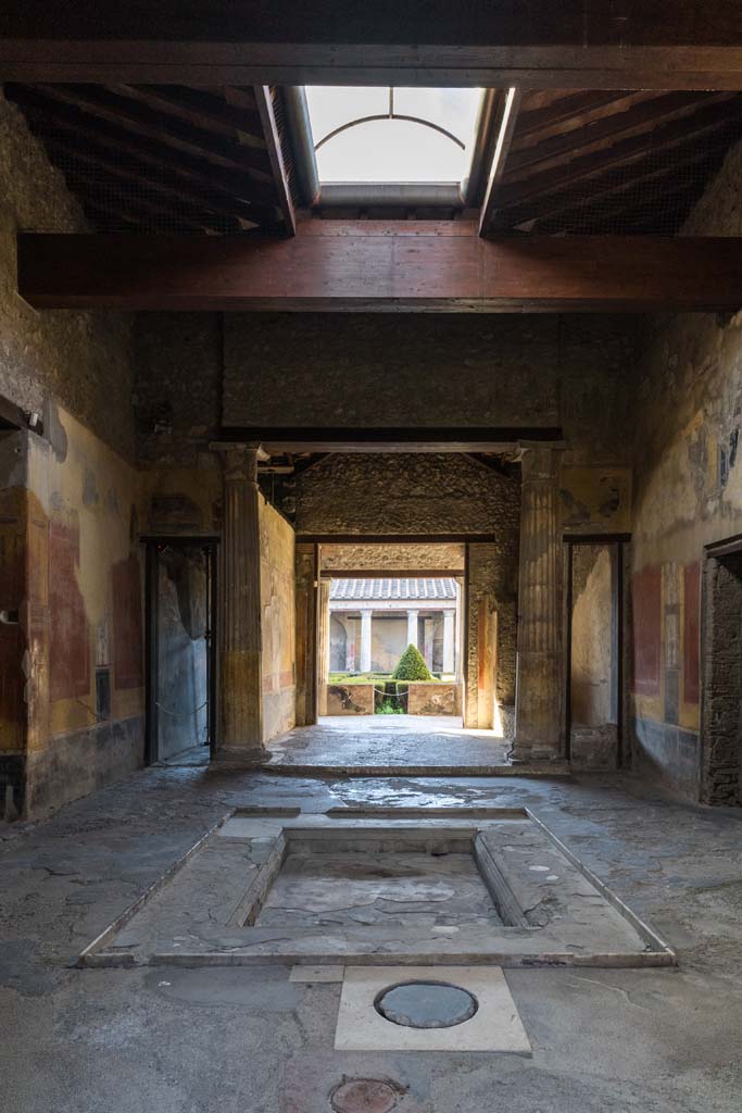 I.10.4 Pompeii. April 2022. 
Looking south across impluvium in atrium towards tablinum and the garden area.
Photo courtesy of Johannes Eber.