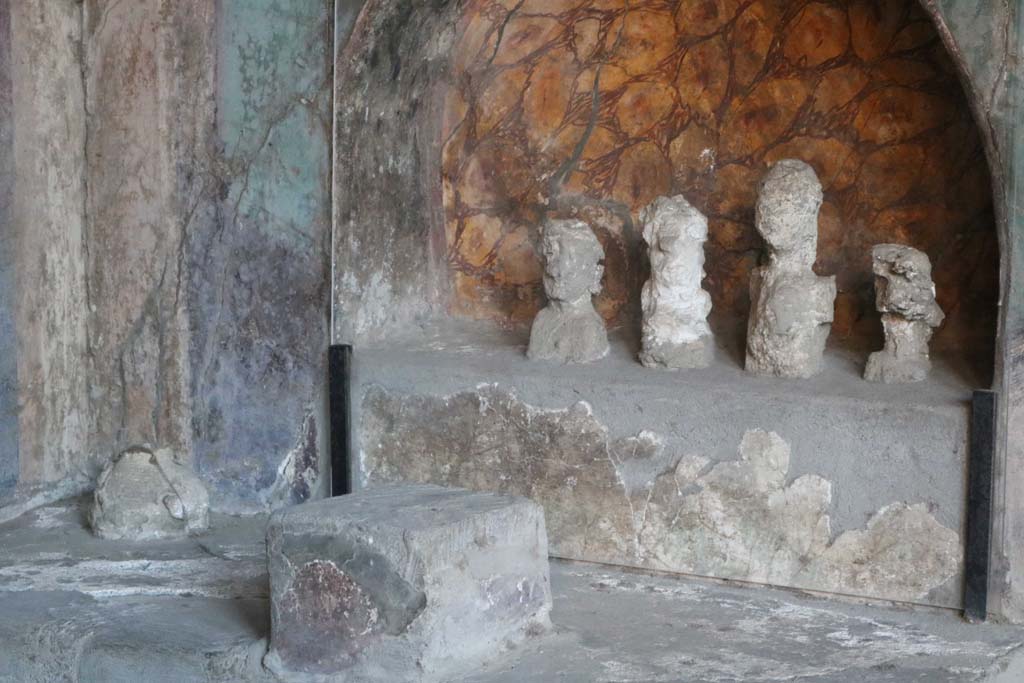 I.10.4 Pompeii. December 2018.  
Alcove 25, lararium or domestic shrine. The busts are plaster cast taken from the cavities left by the original wooden busts. 
Photo courtesy of Aude Durand.