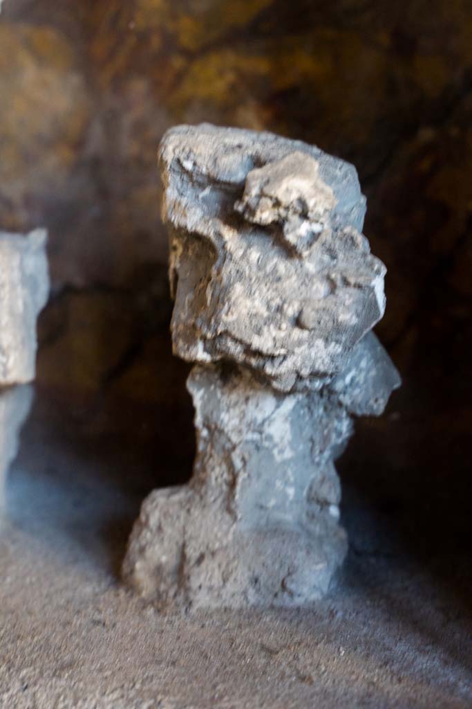 I.10.4 Pompeii. April 2022. 
Alcove 25, detail of plaster cast, on the right, on the lararium or domestic shrine. (Image 2).
Photo courtesy of Johannes Eber.