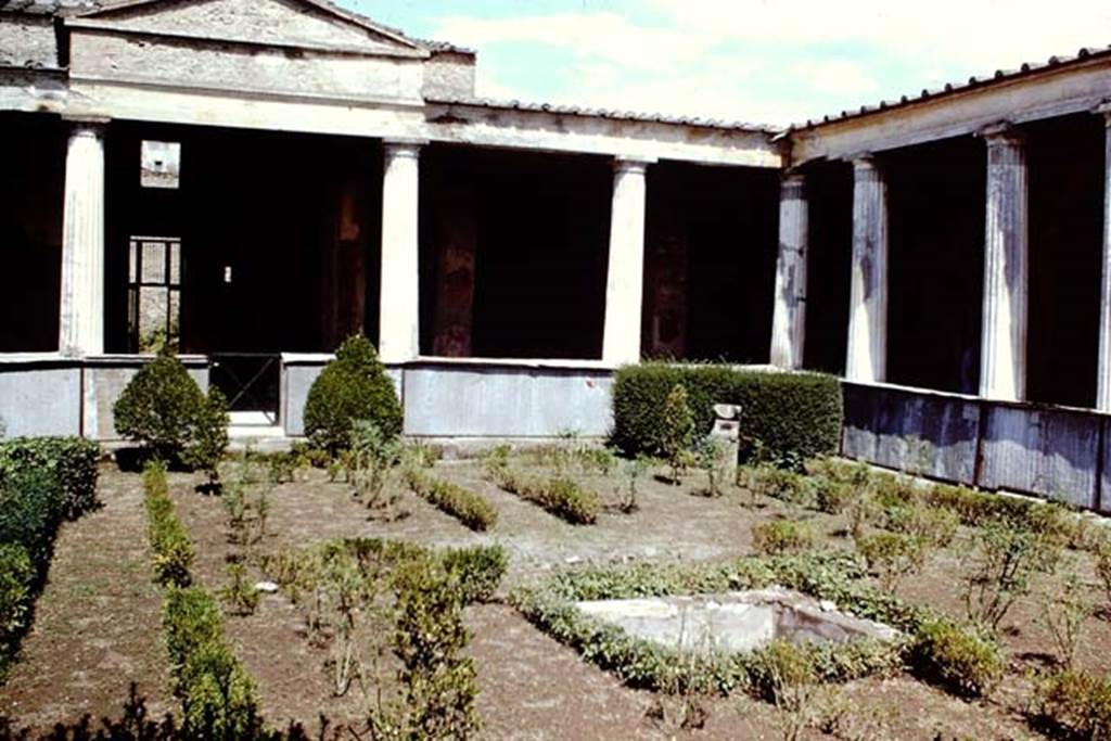 I.10.4 Pompeii, 1968. Looking towards north and north-east corner of peristyle. Photo by Stanley A. Jashemski.
Source: The Wilhelmina and Stanley A. Jashemski archive in the University of Maryland Library, Special Collections (See collection page) and made available under the Creative Commons Attribution-Non-Commercial License v.4. See Licence and use details.
J68f1001
According to Jashemski –
“The imprint of a wooden triclinium, which occupied a rectangular area 1.74 x 2.69m, was found in the garden, and on the south side of the triclinium was a square pool with a fountain. There was a spherical sundial in the north-east of the garden”.
See Jashemski, W. F., 1993. The Gardens of Pompeii, Volume II: Appendices. New York: Caratzas. (p.47).
According to Soprano –
Ubiczione: peristilio.
Bibliog. Maiuri, La Casa del Menandro e il suo tesore di argenteria. (Roma, 1939), p.84 and fig.a on p.75.
Nel peristilio furono rinvenute le impronte di un triclinio ligneo. 
Occupava un’area rettangolare di m.1.74 per 2.69; ad ovest del triclinio c’era una piscina quadrata.
See Soprano, P. (1950). I triclini all’aperto di Pompei. (In Pompeiana, raccolta di studi per il secondo centenario degli scavi di Pompei. Napoli, Gaetano Macchiaroli, Editore, P. 307, no.31).