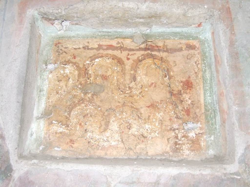 I.10.7 Pompeii. March 2009. Room 12, east wall of triclinium.  
Lararium niche set in third style decoration. Two crested and bearded brown serpents with yellow underbellies are creeping to the left between red flowers and green plants. On the right is an altar.
See Fröhlich, T., 1991. Lararien und Fassadenbilder in den Vesuvstädten. Mainz: von Zabern. (L15: p.256)
According to Boyce, this shallow rectangular niche was set into (but not in the centre of) a fine panel of wall decoration, which it disfigured.
(According to the note by Boyce, Elia had said in Not.Scavi, that these panels were painted shortly after the earthquake of 63 AD).
Both serpents coil from the left towards an altar, as in the other lararium described in the kitchen. In the background were green plants with red flowers. Not. Scavi, 1934, 287.
See Boyce G. K., 1937. Corpus of the Lararia of Pompeii. Rome: MAAR 14. (p.29, no.57)