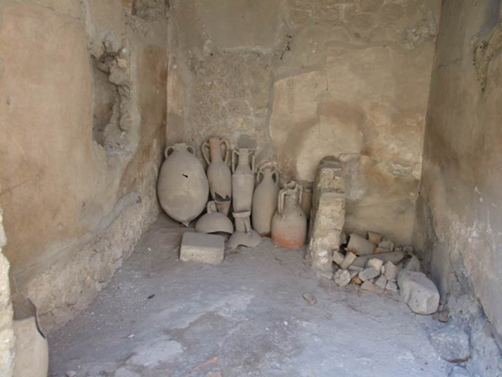 I.10.7 Pompeii. March 2009. Room 1, west wall, with latrine in north-west corner.
According to NdS –
The upper floor: 
Above the west side of the atrium and above the oecus (room 8) would have been a small area of five or six rooms, all more or less decorated in a scheme of the 4th Style.  The upper parts of the walls were preserved only partially for the first 4 rooms nearer to the roadway; all the rest were destroyed and reconstructable only by some traces. The access to this series of rooms would have been by the wooden stairs of room 1, which passed over the top of the latrine but there was also a masonry staircase which led to the walkway above the kitchen,
See Notizie degli Scavi, 1934, (p.292)