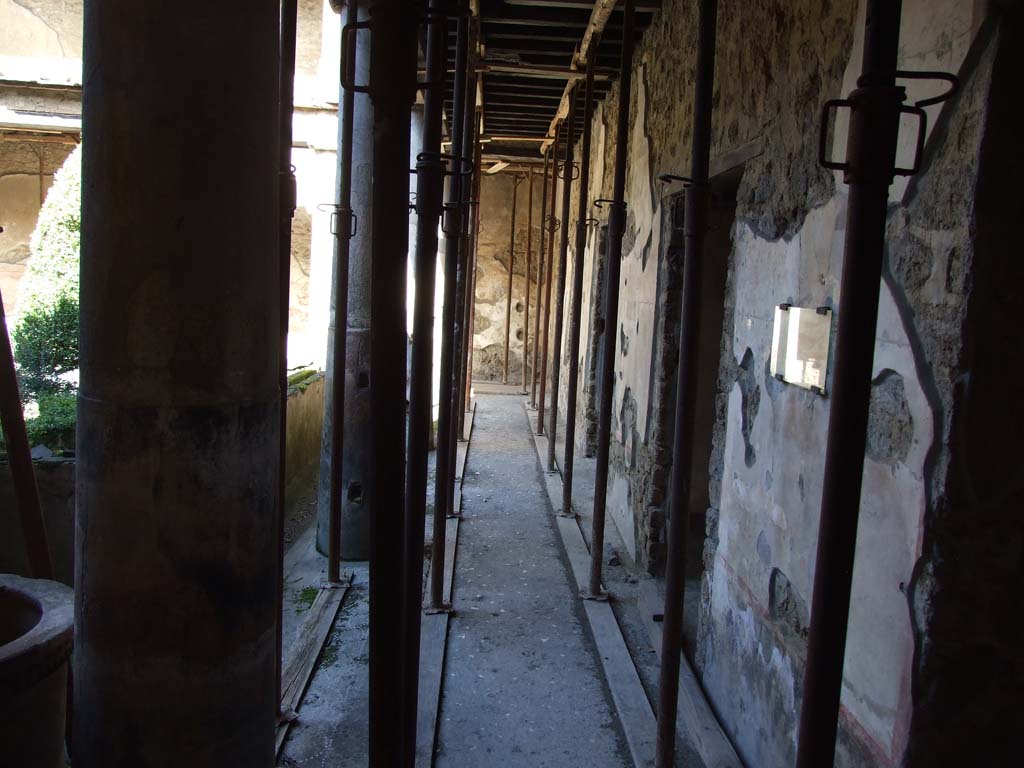 I.10.11 Pompeii. March 2009. Room 10, looking north along east side of portico in peristyle.  
The graffito of CIL IV 8408 a – c can be seen on the right side of the photo on the plastered wall.