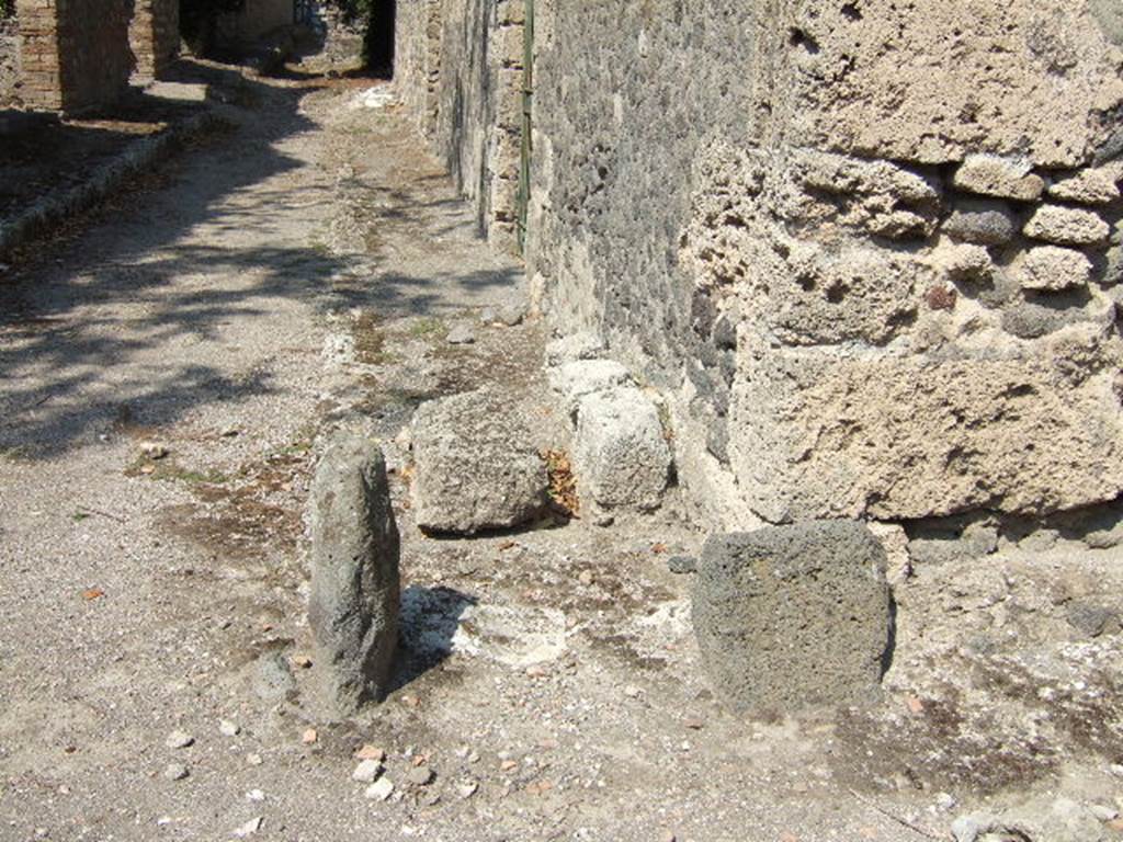 I.10.11 Pompeii. September 2005. Corner with remains of stone bench, looking north.
