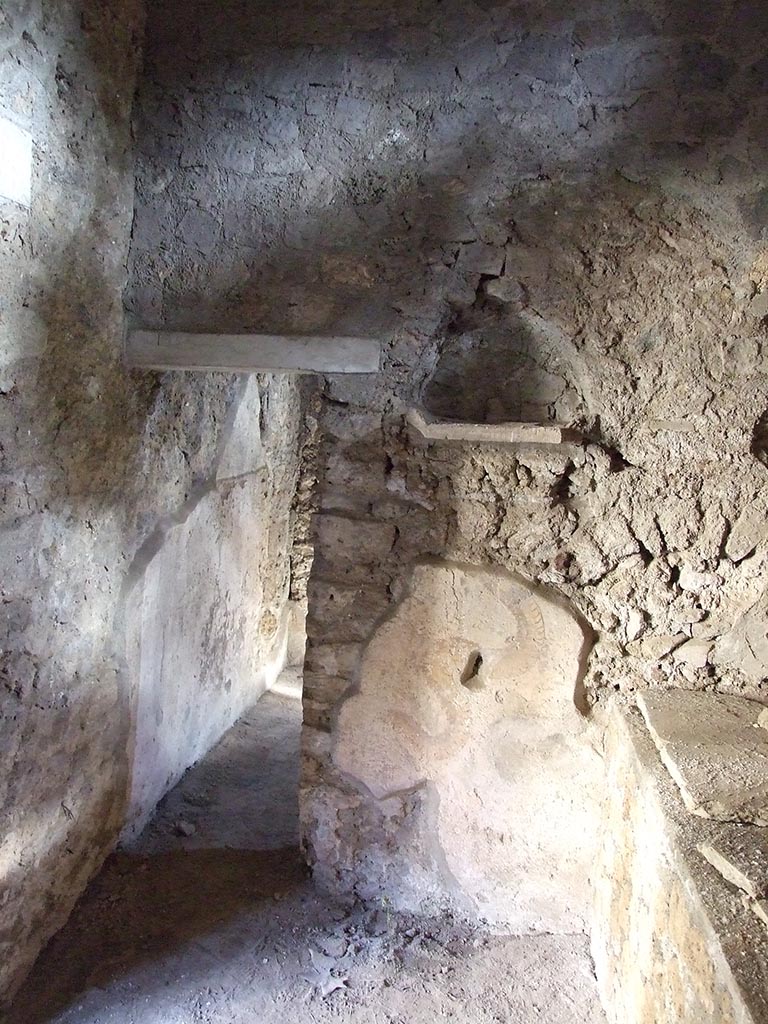 I.10.11 Pompeii. March 2009. 
Room 15, east wall of kitchen with niche and remains of painted serpent from lararium painting.
On the left is the doorway to room 16.