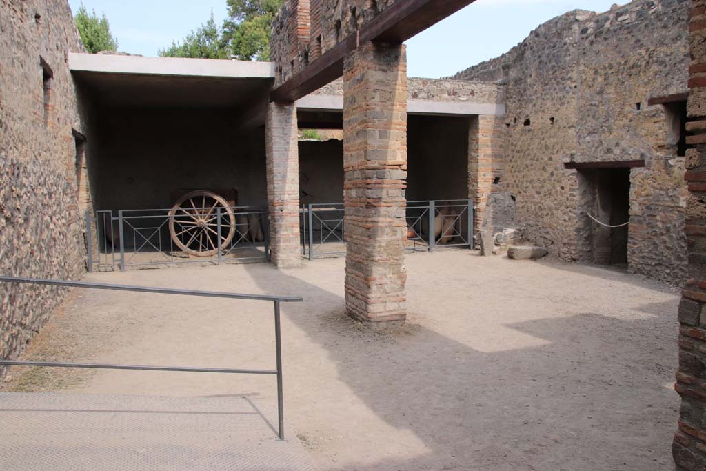 I.10.14, Pompeii. September 2021. 
Looking towards east side of stable, with two-wheeled cart and blocked doorway. Photo courtesy of Klaus Heese.