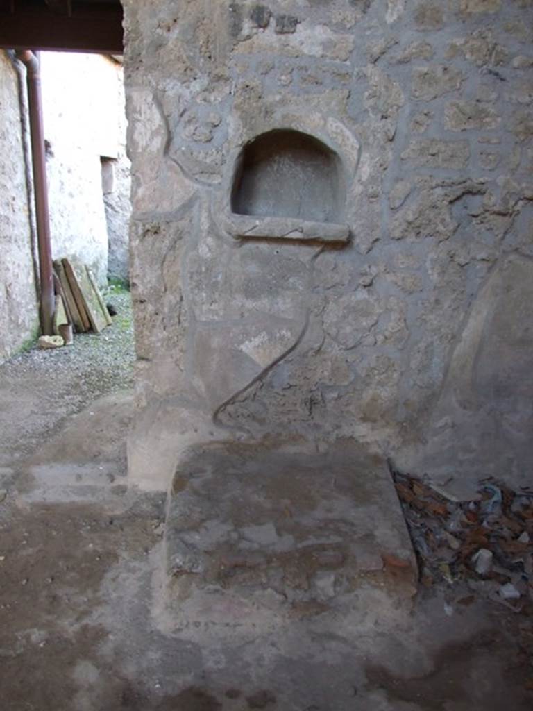 I.10.16 Pompeii. March 2009. Niche in atrium. According to Boyce, on this west wall above a small hearth was an arched niche with projecting floor. Its inside walls were coated with the same rough stucco as the walls of the room. When Boyce wrote, he said that still standing within the niche were three terracotta lamps. They each had a single nozzle, two of them were ornamented with reliefs, one of the sun, one of an eagle. Also found there was a small saucer-like dish. See Boyce G. K., 1937. Corpus of the Lararia of Pompeii. Rome: MAAR 14. (p.28, no.52)
