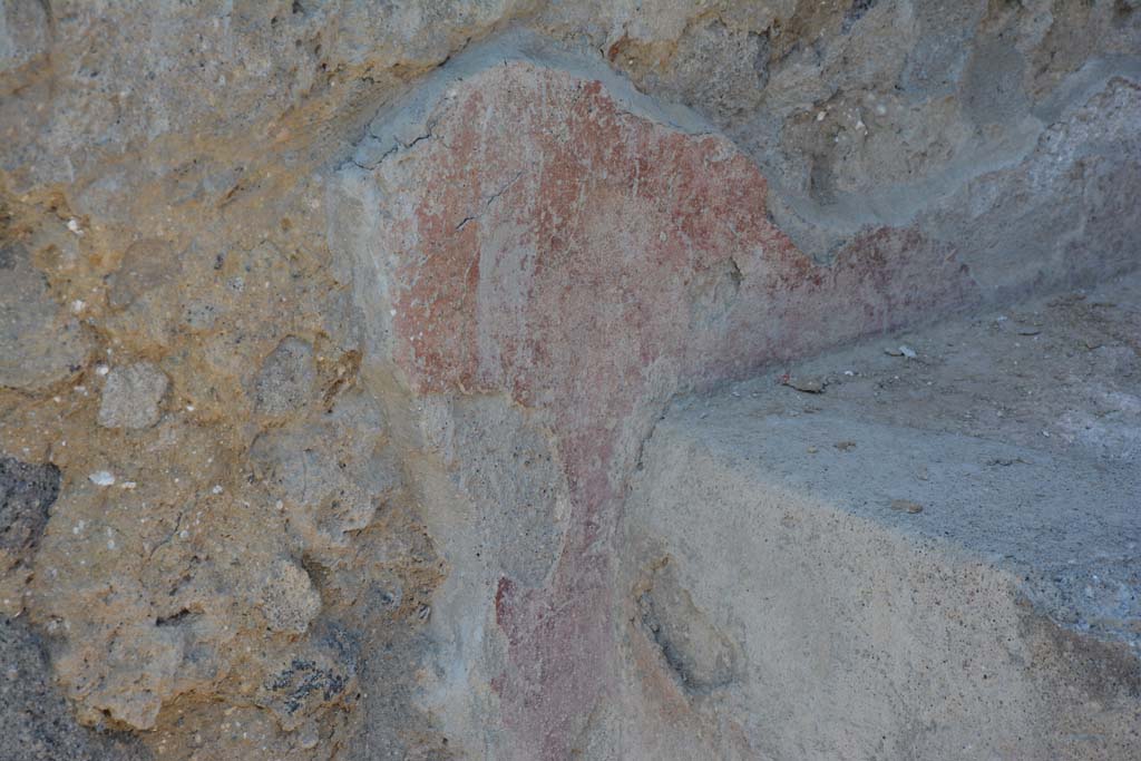 I.10.18 Pompeii. April 2017. Detail of remaining painted plaster at rear of bench seating on south side of entrance doorway. 
Photo courtesy Adrian Hielscher.
