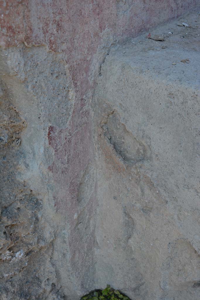 I.10.18 Pompeii. April 2017. 
Detail of remaining painted plaster on south side of bench seating on south side of entrance doorway. 
Photo courtesy Adrian Hielscher.