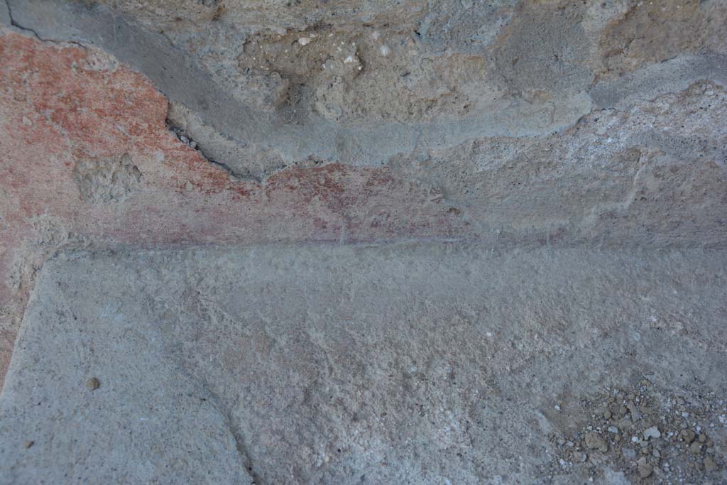 I.10.18 Pompeii. April 2017. Detail of remaining painted plaster at rear of bench seating on south side of entrance doorway. 
Photo courtesy Adrian Hielscher.