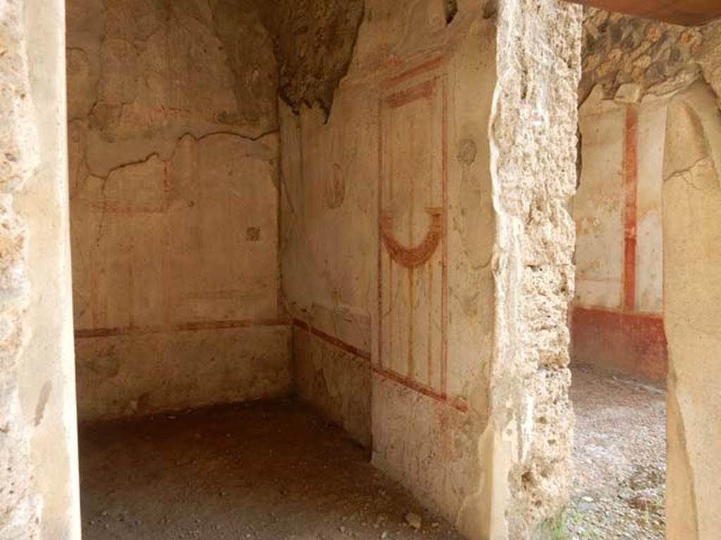 I.11.1 Pompeii. May 2015. South wall of the cubiculum. Photo courtesy of Buzz Ferebee.  “The room to the east of the thermopolium, (room b) and communicating with it, was a cubiculum with rather neglected decorations of the IV Style, where only a few fragments of the barrelled ceiling could be recovered.  On the eastern side was the recess for the bed and, in the cocciopesto floor, a central decoration of a chessboard in diamond shapes, made with minute white marble tesserae.   In the centre of the largest panels of the walls were three medallions of 0.28m diam.   In the south wall, the head of Diana with diadem facing front, with bow raised high in the left hand, and quiver behind the right shoulder, and the other two from the north wall were of the head of Bacchus, crowned with vine leaves facing front, and with slender staff on the right shoulder, and of nude Apollo in threequarters looking right, with his lyre held between his hands.  In the smaller space (east wall), flying towards the centre, two naked Cupids, one holding   a long lamp and a tray, and the other something like an umbrella.”
See Notizie degli Scavi, 1913, p.249-50.
(L’ambiente ad est del termopolio, e con esso comunicante (b), era un cubicolo con decorazioni piuttosto trascurate di IV stile, del cui soffitto a botte soltanto pochi frammenti si sono potuto recuperare. Nel lato orientale era il rincasso per il letto e, nel pavimento di cocciopesto, una scacchiera centrale a reticella di rombi, fatta con tesserae minute di marmo bianco. Al centro dei maggiori riquadri delle pareti, tre medaglioni di 0.28m di diam. esibiscono l’uno (parete sud) il busto di Diana, di fronte, diademata, con arco nella sinistra levata in alto e turcasso dietro la spalla destra, e gli altri due (parete nord) i busti di Bacco di fronte, coronato di foglie di vite e con esile tirso sulla spalla destra, e di Apollo, in terza a destra, nudo, con la cetra stretta fra le mani.
 Negli spazi minori (parete est) convergono, volando verso il centro, due Eroti nudi, reggenti l’uno una lunga face e un vassoio, e l’altro come un ombrello.)