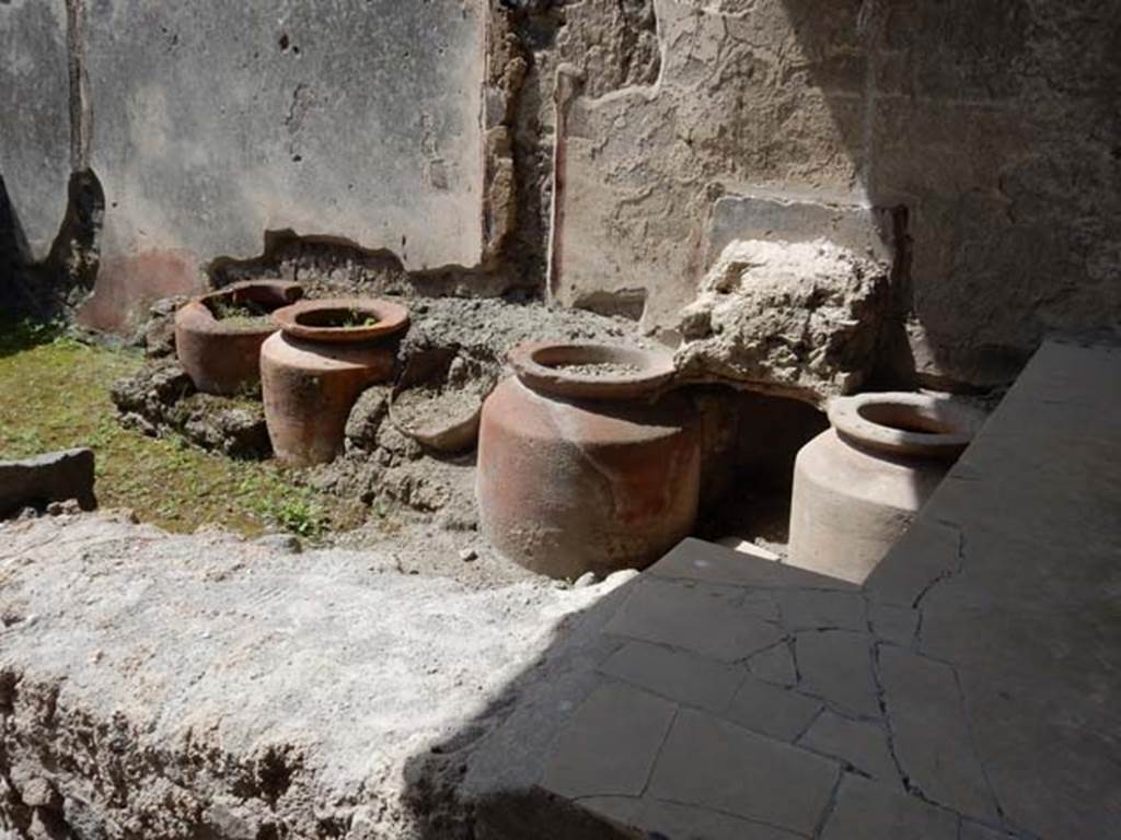 1.11.1 Pompeii. May 2015. West side with remains of four urns and shelves for displaying drinking vessels.
Photo courtesy of Buzz Ferebee.
