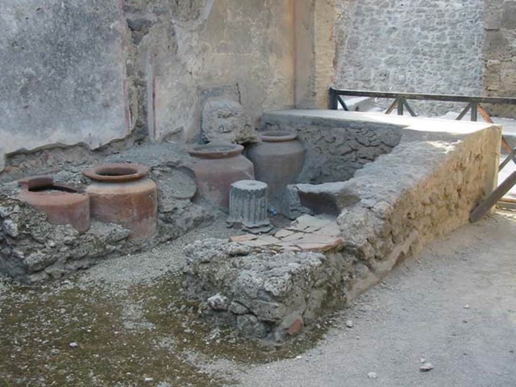 I.11.1 Pompeii. May 2003. Looking towards west wall with four urns, and remains of shelving. Photo courtesy of Nicolas Monteix