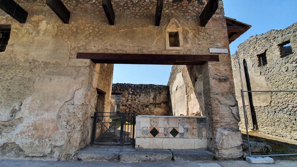 I.11.1 Pompeii. July 2021. 
Looking south on Via dell’Abbondanza towards entrance doorway, with unnamed vicolo between I.11 and I.9, on right.
Foto Annette Haug, ERC Grant 681269 DÉCOR.