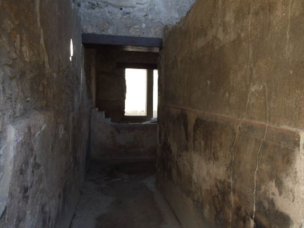 I.11.16 Pompeii. December 2006. Room 1, looking east along entrance corridor.
According to Packer, the fauces was floored with opus signinum, along with all the other rooms  (although he stated rooms 10-12 could not be seen because of the rubbish which concealed the floors).  The walls were found with a high black dado (zoccolo) with a red border which set off the plain white stucco walls.