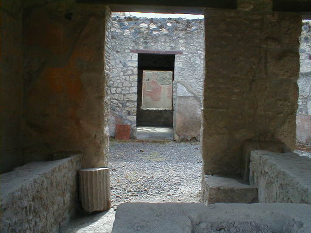 I.12.5 Pompeii. September 2004. 
Looking south through rear of caupona across atrium to doorway to triclinium with window onto garden.