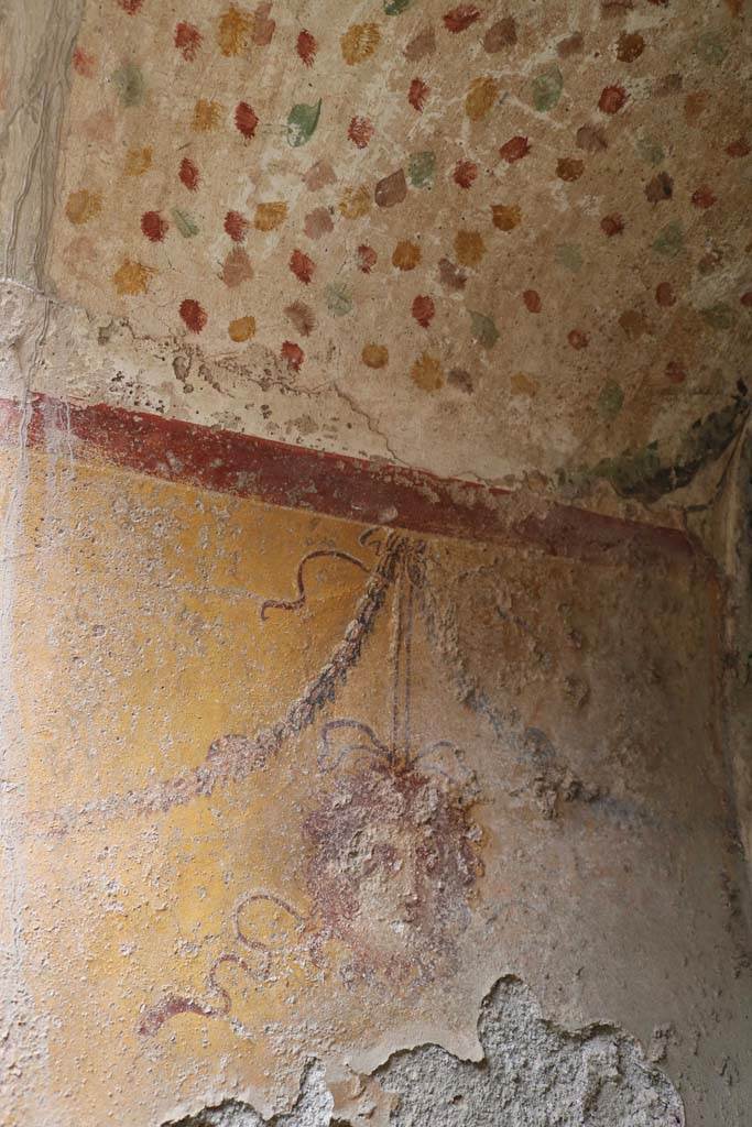 I.12.5 Pompeii. December 2018. 
North wall of painted Lararium, with mask hanging from a garland. Photo courtesy of Aude Durand.