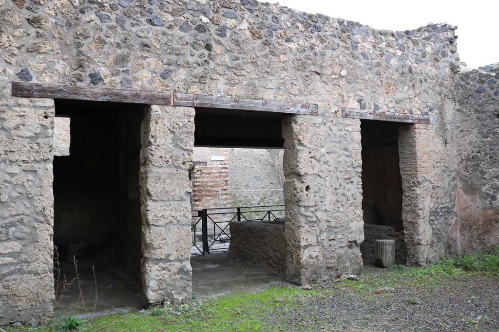 I.12.5 Pompeii. December 2018. 
Looking north from atrium towards doorway to cubiculum, on left, and through rear of caupona towards Via dell’Abbondanza, centre and right. 
Photo courtesy of Aude Durand.