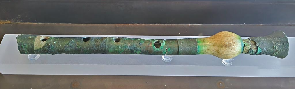 I.12.6 Pompeii. March 2024. Photo courtesy of Giuseppe Ciaramella.
No.10, flute made of bone and sheet bronze. (Ist century AD). (Flauto in osso e lamina do bronzo (I sec. d.C). 
On display in exhibition in Palaestra entitled – “L’altra Pompei, vite comuni all’ombra del Vesuvio”.