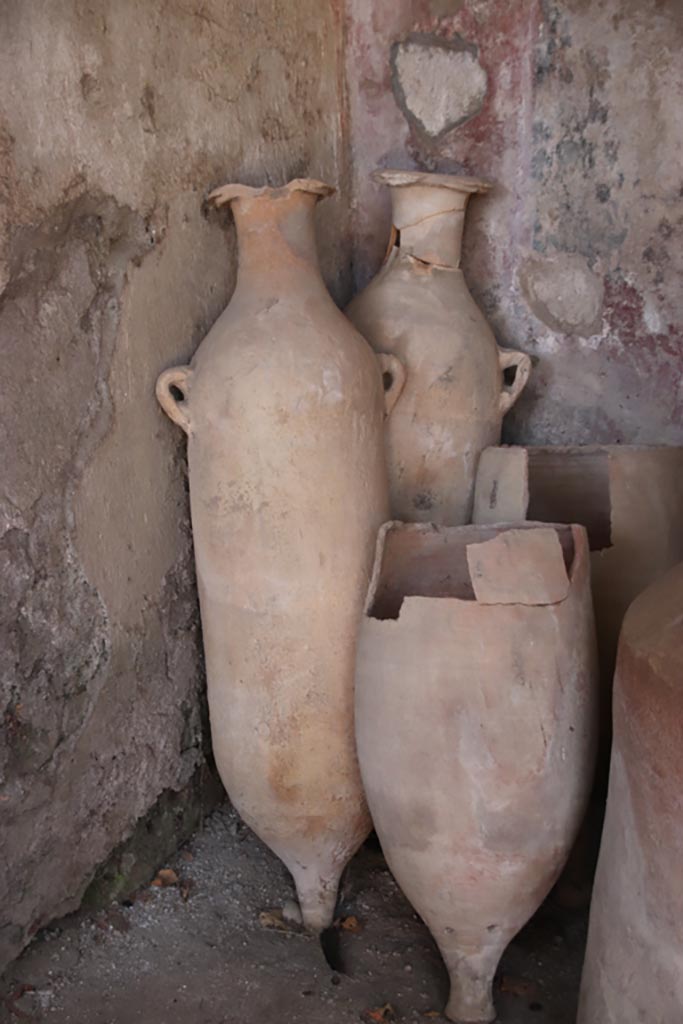 I.12.8 Pompeii. October 2022. 
Terracotta amphorae in north-west corner of peristyle 9. Photo courtesy of Klaus Heese.