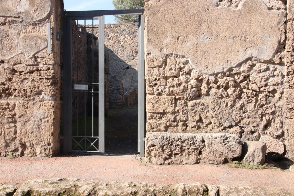 I.12.8 Pompeii. October 2022. 
Looking north towards entrance doorway, with bench/seat on east side. Photo courtesy of Klaus Heese.
