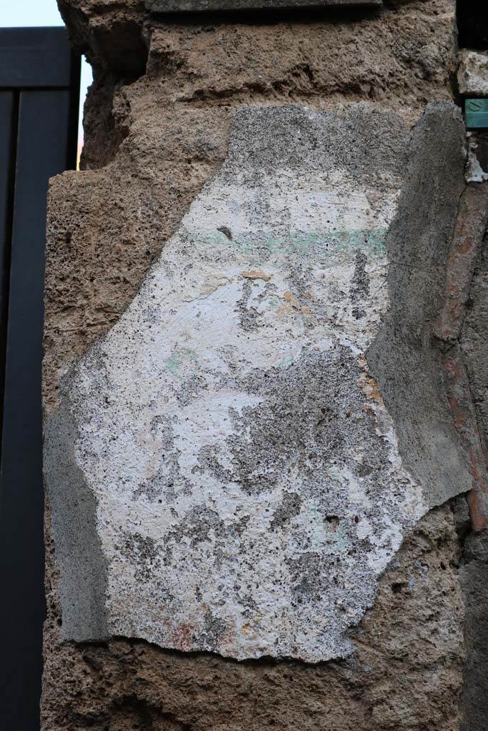 I.12.11 Pompeii. December 2018. Pilaster on east of entrance doorway, site of wall painting of Hercules.
Remains of painted plaster on east side of doorway, the remains of the “garland” are just visible.
Photo courtesy of Aude Durand.