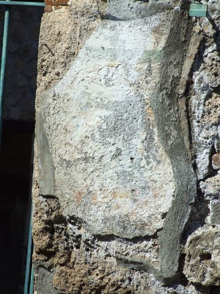 I.12.11 Pompeii. March 2009.  Remains of painted plaster on east side of doorway, which was the site of the wall painting of Hercules. The remains of the “garland” are just visible.