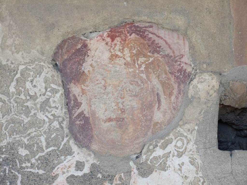 I.12.15 Pompeii. March 2009. Room 5, lararium.  Detail of a face on north side of the niche on the east wall.