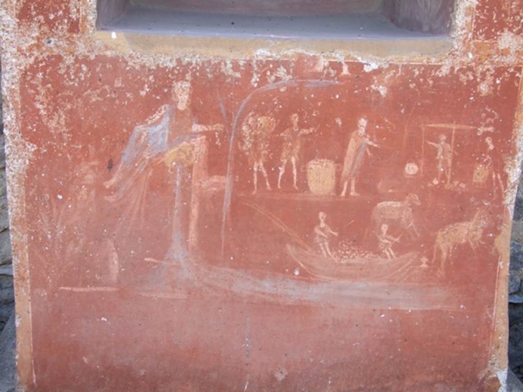 II.14.7 Pompeii.  March 2009.  Base of Lararium. The River God Sarnus is shown pouring water into the river , and overlooking the busy activity at the harbour. This includes produce being delivered and weighed, of donkeys and mules carrying goods to and from barges, and a boat loaded with produce.