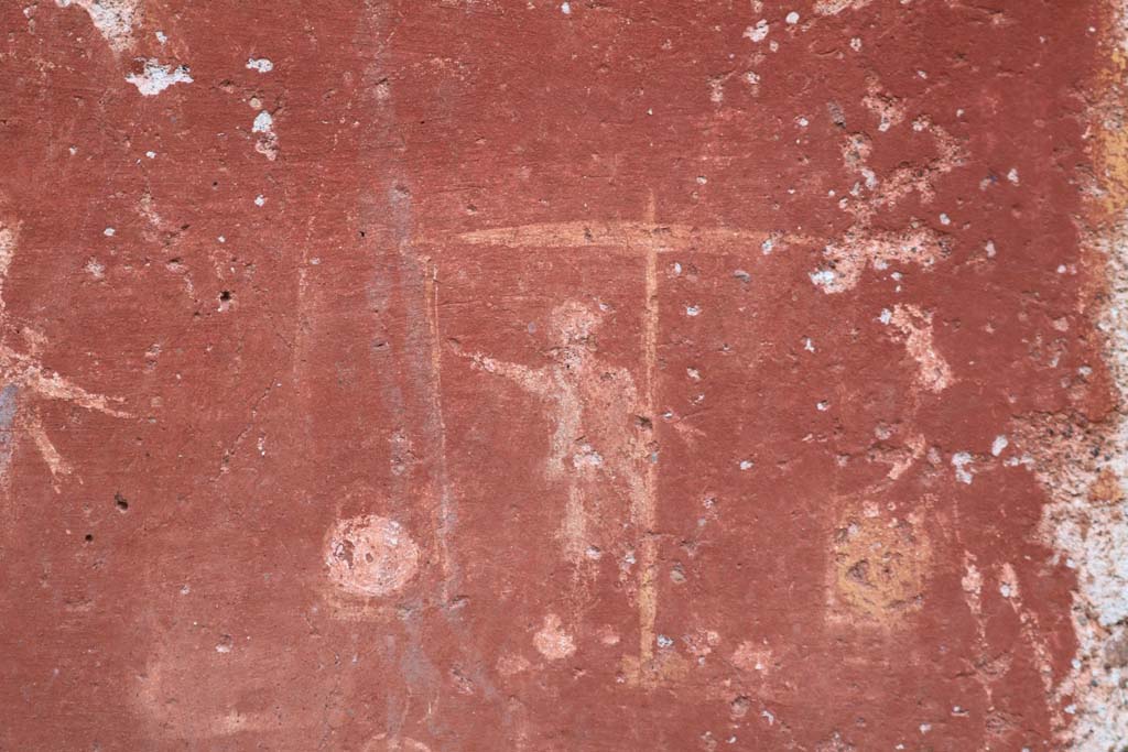 I.14.7 Pompeii. December 2018. Detail from base of lararium. 
Two men in short robes weighing two baskets on large weighing scales. Photo courtesy of Aude Durand.