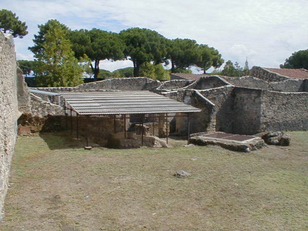 I.14.10 Pompeii. September 2004.  Looking east towards the triclinium, the inspection shaft of the Sarno Canal and the entrance to I.14.4.