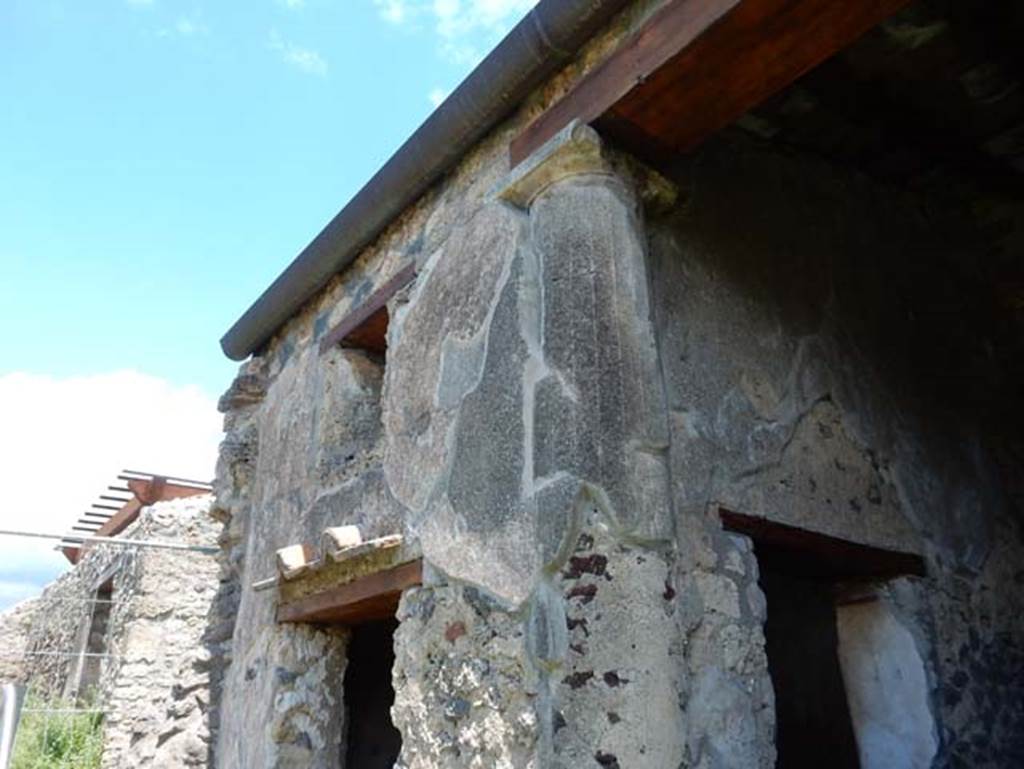 I.14.12, Pompeii. May 2018. Room 2, exterior east wall with window and doorway from peristyle garden. When this room was constructed one of the columns of the original peristyle was embedded into the south-west corner of the room. 
Photo courtesy of Buzz Ferebee.