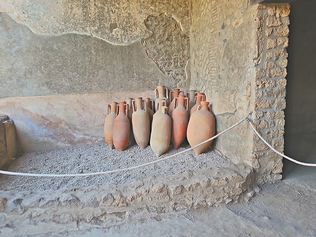 I.15.3 Pompeii. September 2024. 
Tub or basin on east end of south portico 10 of peristyle 13 with amphorae. Photo courtesy of Giuseppe Ciaramella.