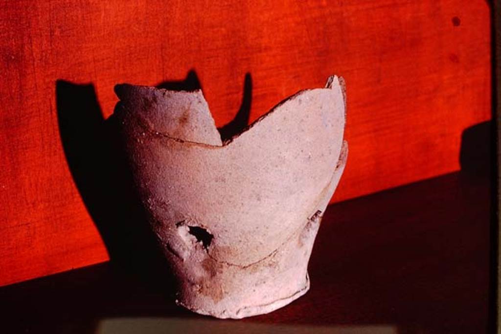 I.15.3 Pompeii. 1972. Terracotta pot from the soil. Photo by Stanley A. Jashemski. 
Source: The Wilhelmina and Stanley A. Jashemski archive in the University of Maryland Library, Special Collections (See collection page) and made available under the Creative Commons Attribution-Non Commercial License v.4. See Licence and use details. J72f0819
According to Wilhelmina, 
“….Among the important discoveries in this garden were the 28 terracotta pots found embedded in the soil at varying depths, at intervals along the 4 walls.  With the exception of six half-pots, these were similar to the two that had been previously found.  8 of the pots were only slightly below the surface of the ground.  14 were found at the bottom of root cavities ranging in depth from 7 to 42 cm.  A cluster of 6 appeared to be half pots. The pots, with one exception, have one hole in the bottom and 3 on the sides.   All of these pots (13 of which were sufficiently complete to be restored) are of a coarse clay and vary in colour from red to black”.
See Jashemski, W. F., 1993. The Gardens of Pompeii, Volume II: Appendices. New York: Caratzas. (p.62)