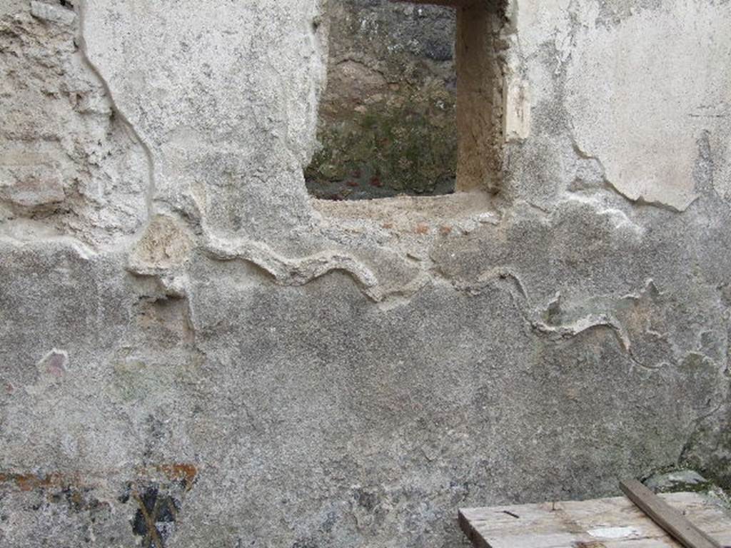 I.16.3 Pompeii. December 2006. South wall of rectangular area, garden or pool?   Remains of a serpent, and with a small altar below the head of the serpent, both in stucco relief. According to Giacobello, in stucco on the south wall a serpent slides towards an altar. The scene was placed on the inside of a picture of a garden, today vanished, with plants, flowers and birds. Behind the decorated wall one finds a basin with well and a flowerbed in front.  See Giacobello, F., 2008. Larari Pompeiani: Iconografia e culto dei Lari in ambito domestico.  Milano: LED Edizioni. (p.234)